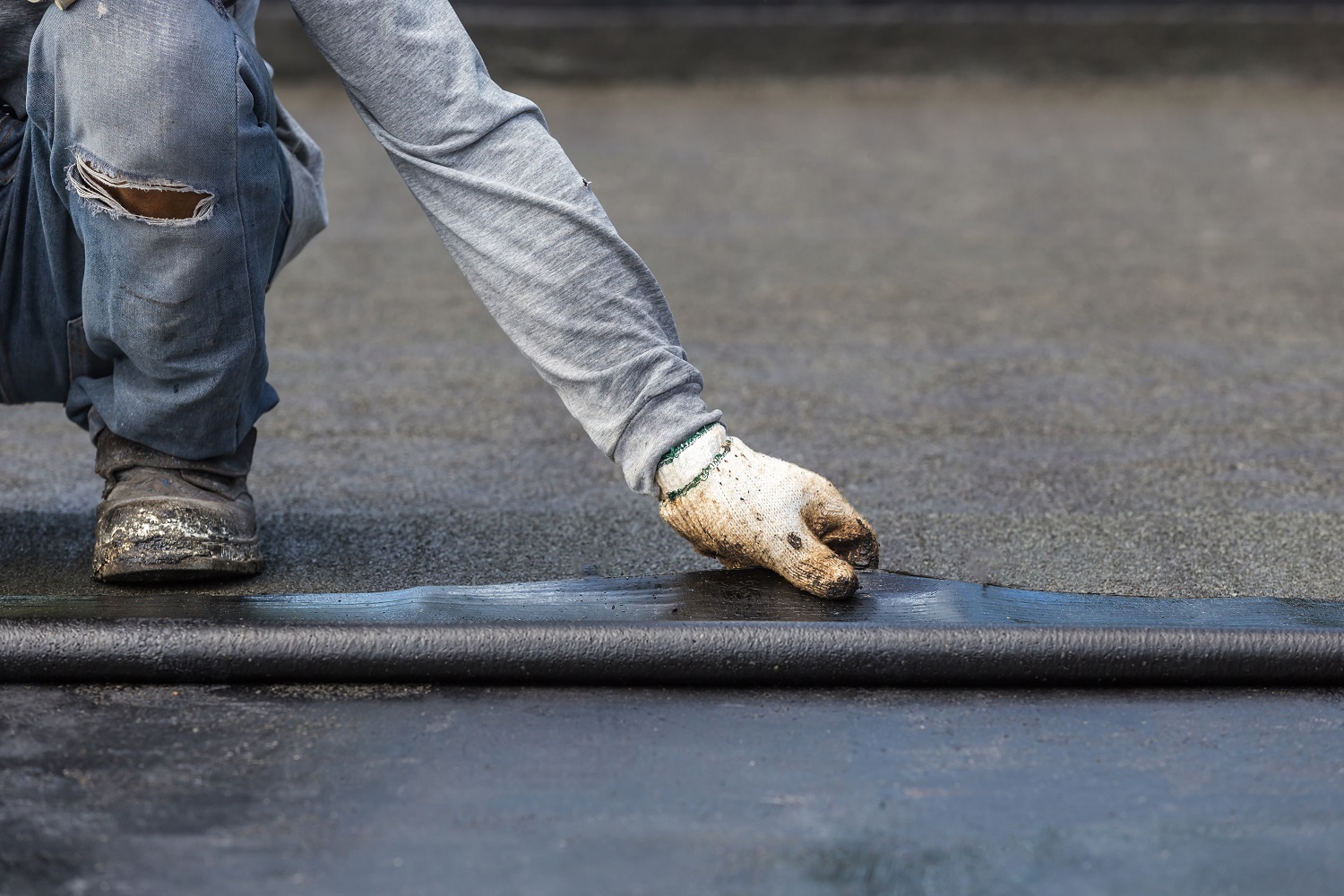 Asia worker installing tar foil on the rooftop of building. Waterproof system by gas and fire torching