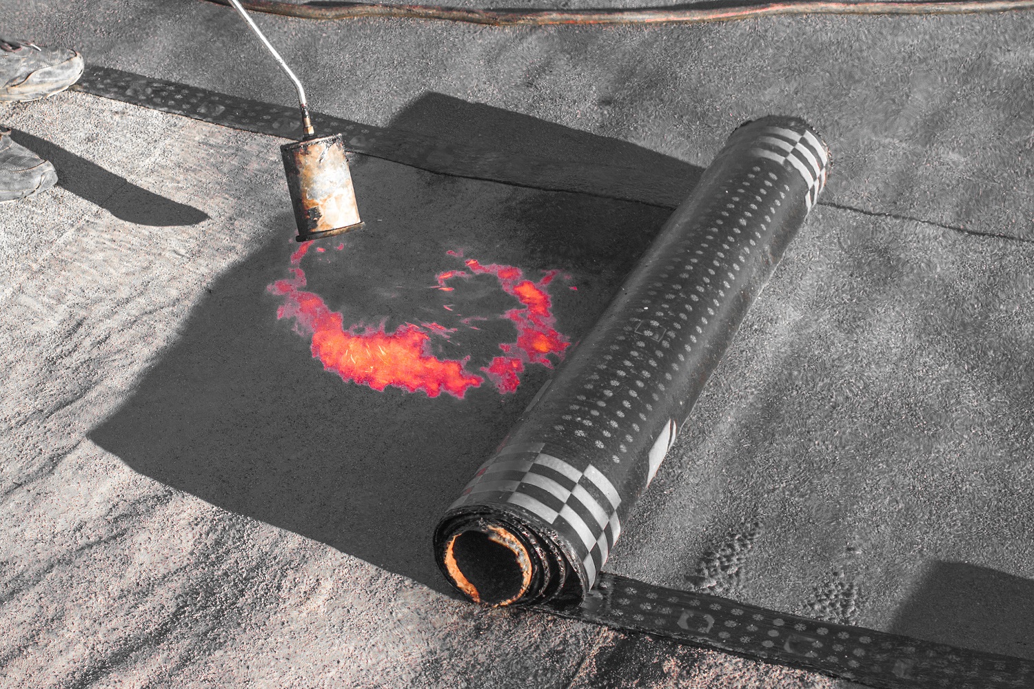 Roll roofing Installation with propane blowtorch during construction works
